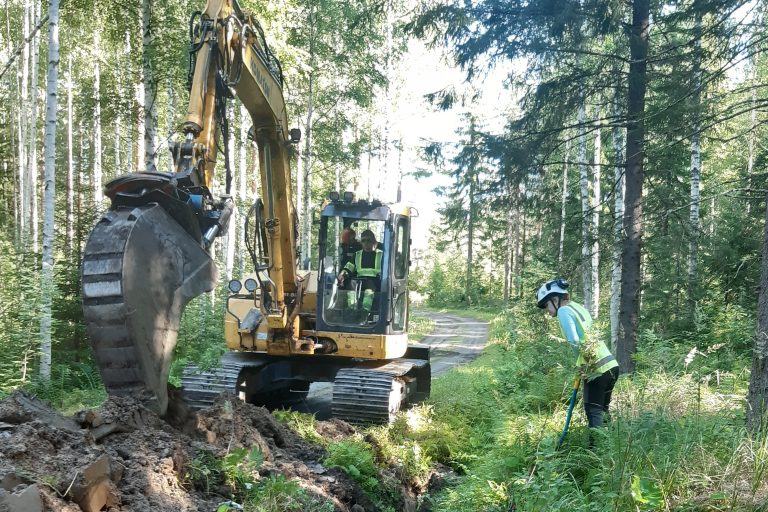 Arkeologi valvoo maakaapeliojan kaivutyötä.